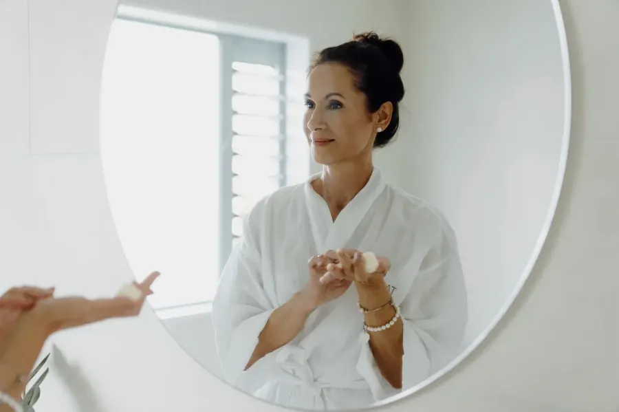 Andrea Taimana applying an essence at a mirror